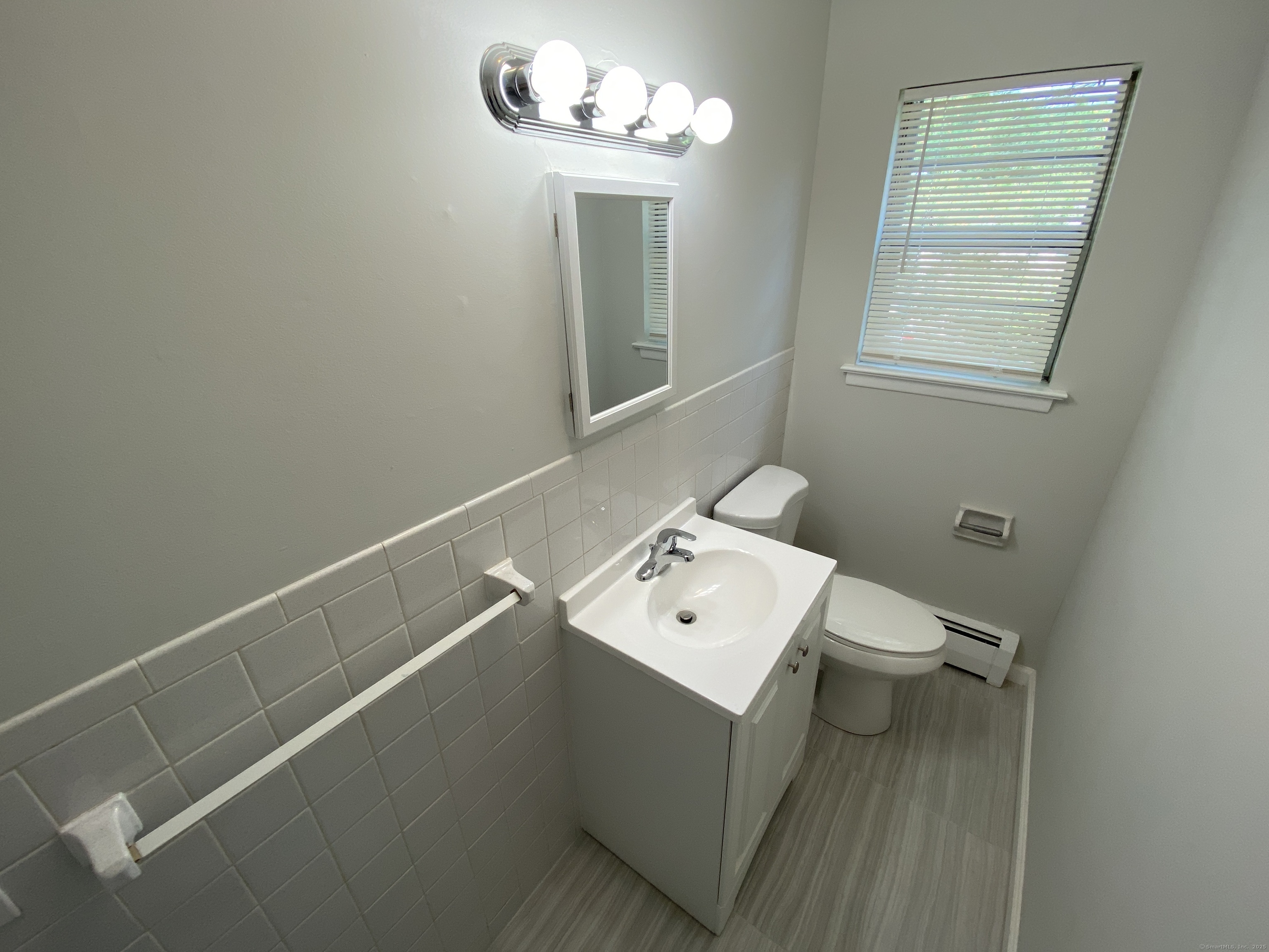15 Elizabeth Street, Unit 31 West Haven, CT 06516 - Photo 6 of 9 a bathroom with a sink a toilet and a mirror