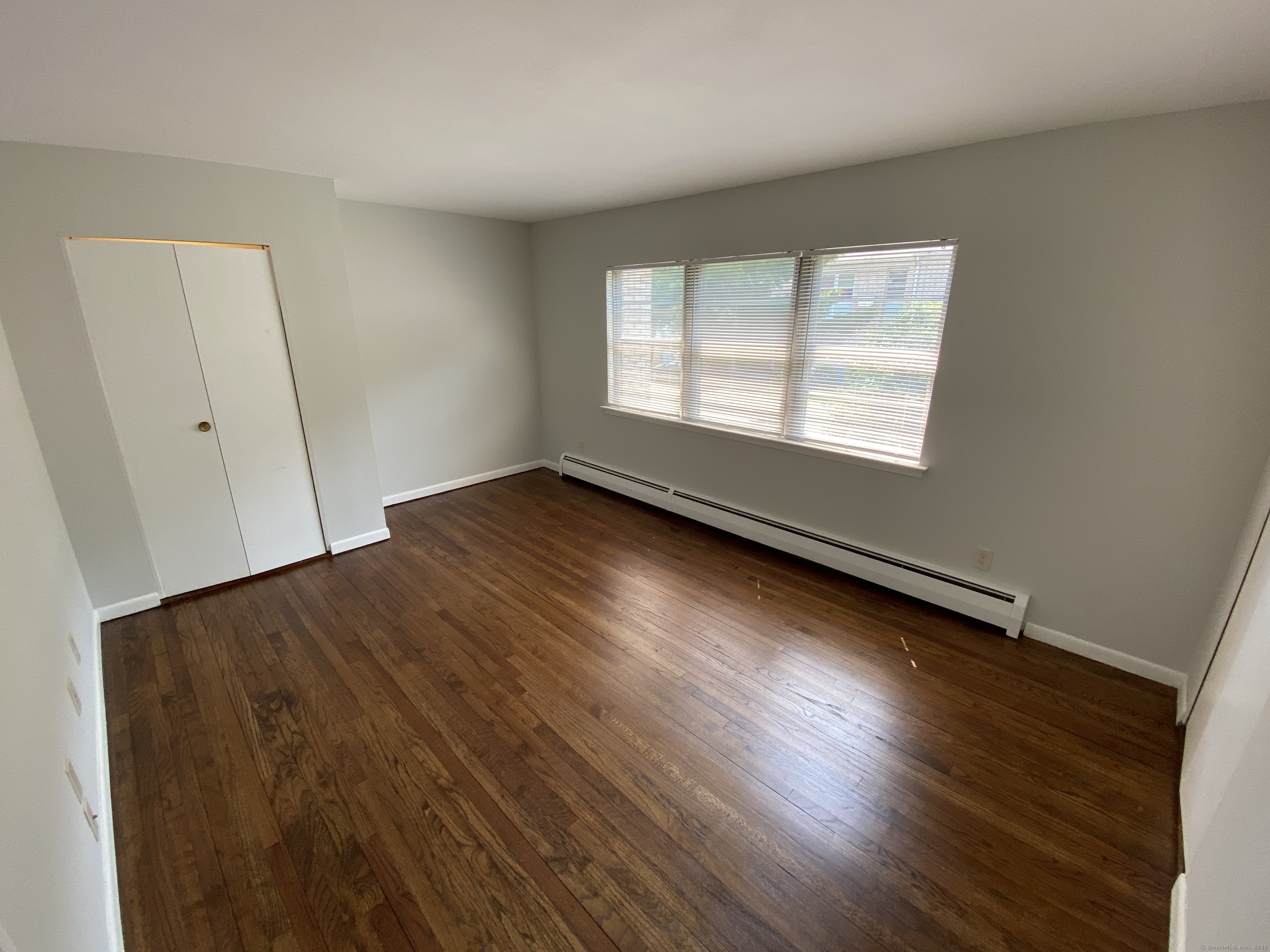 15 Elizabeth Street, Unit 31 West Haven, CT 06516 - Photo 7 of 9 an empty room with wooden floor and windows