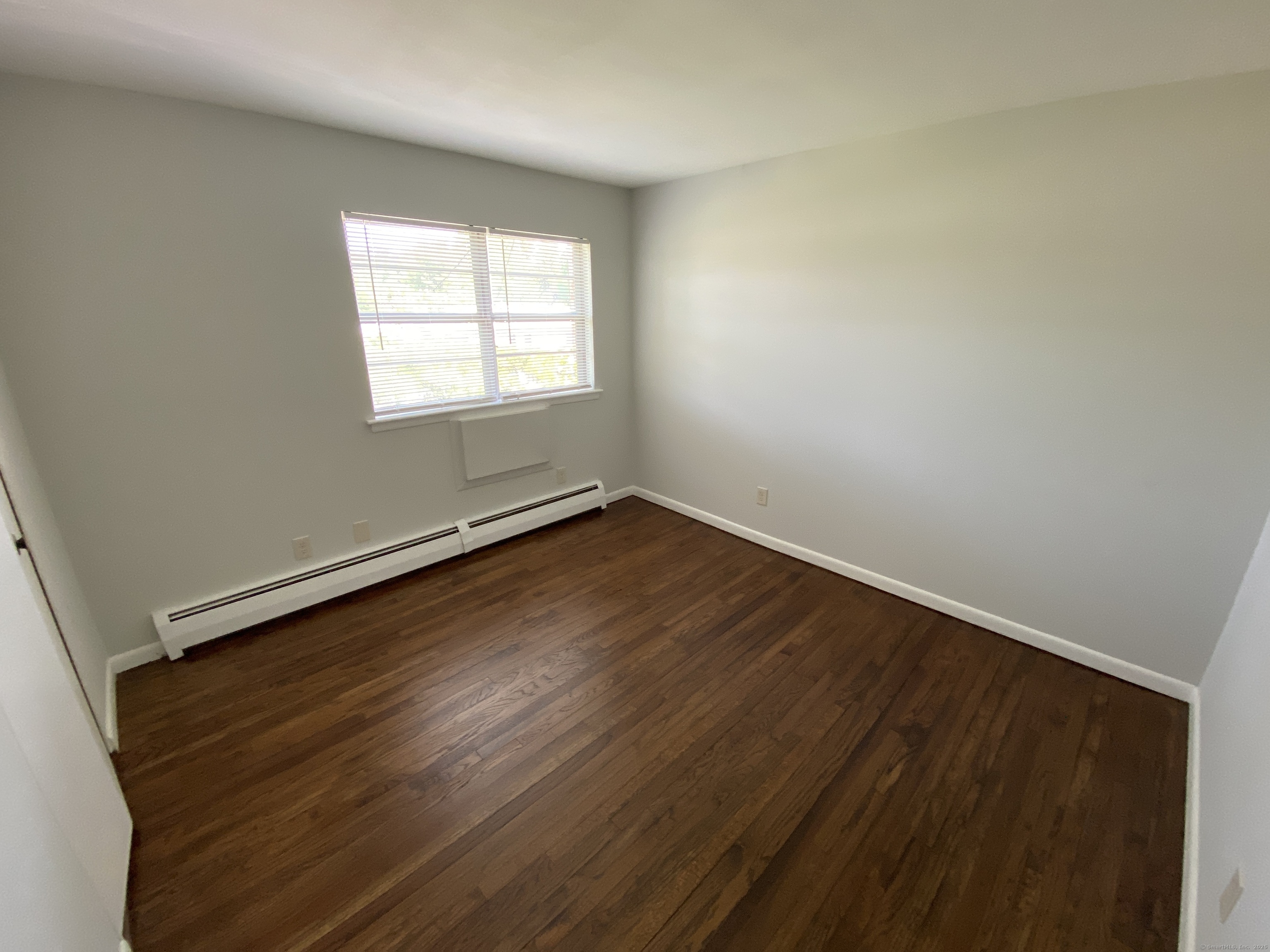 15 Elizabeth Street, Unit 31 West Haven, CT 06516 - Photo 8 of 9 an empty room with wooden floor and windows
