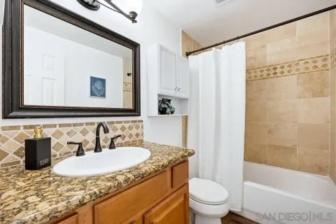 a bathroom with a granite countertop sink and a mirror