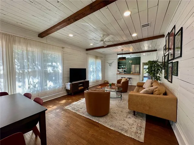 a living room with furniture a flat screen tv and a large window