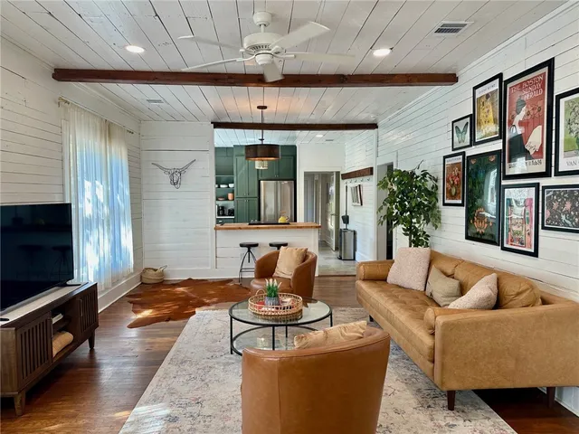 a living room with furniture a flat screen tv and a fireplace