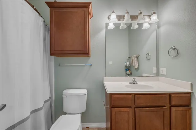 a bathroom with a sink a toilet and mirror