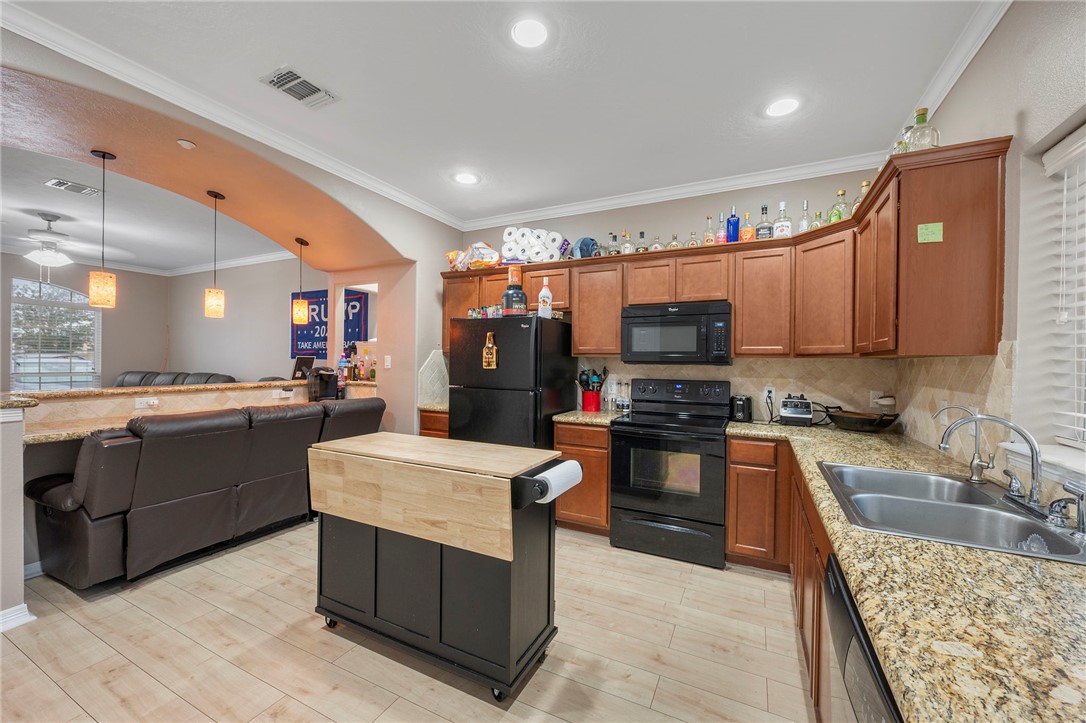 1198 Jones-Butler Road, Unit 2109 College Station, TX 77840 - Photo 3 of 16 a kitchen with stainless steel appliances granite countertop a stove top oven a sink dishwasher and a refrigerator with wooden floor