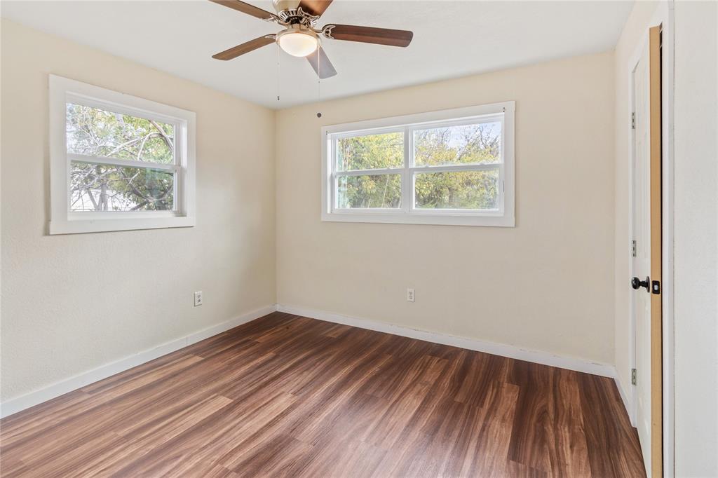 212 East 2nd Street Coleman, TX 76834 - Photo 12 of 17 a view of an empty room with wooden floor and a window