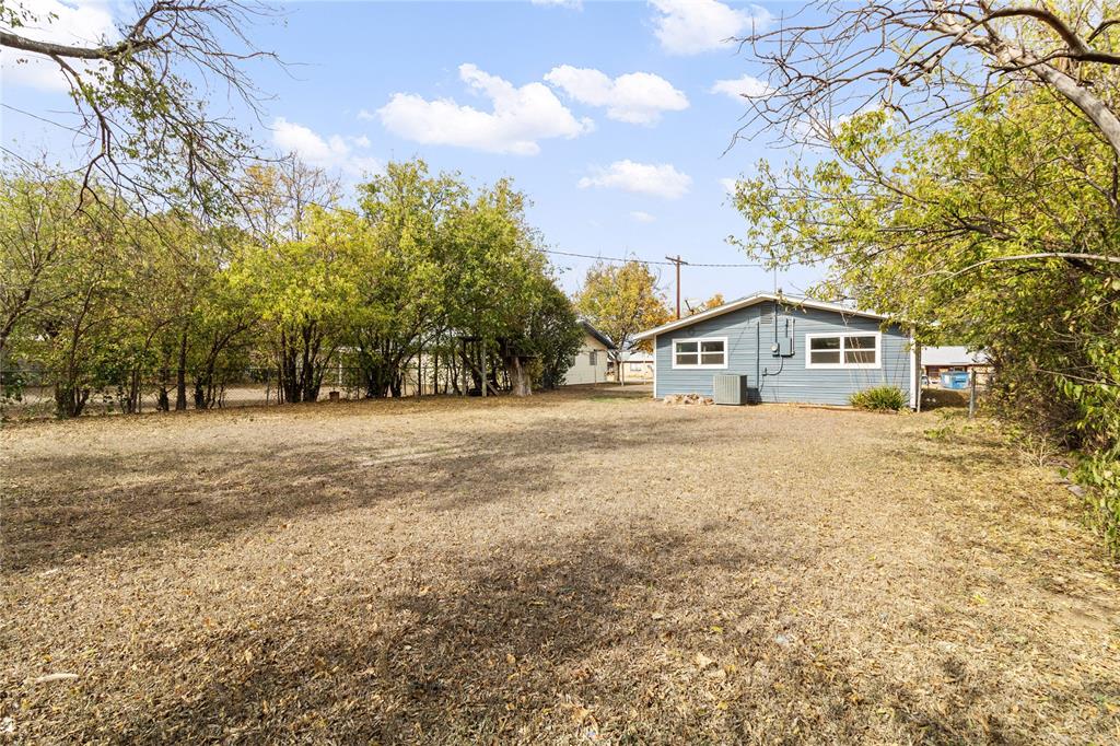 212 East 2nd Street Coleman, TX 76834 - Photo 16 of 17 a front view of a house with a yard covered with snow and trees
