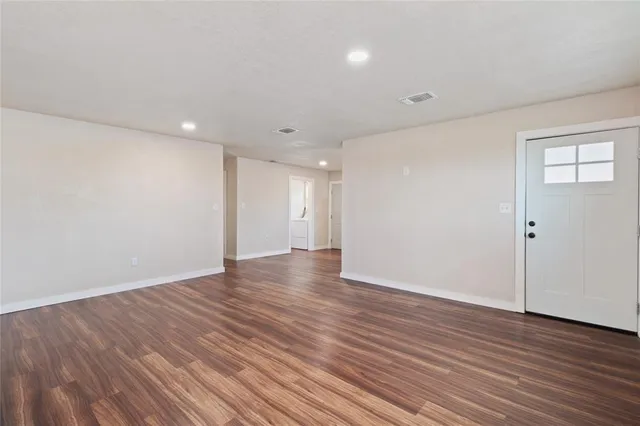 a view of an empty room with wooden floor