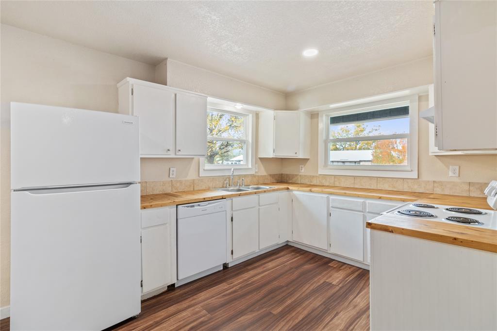 212 East 2nd Street Coleman, TX 76834 - Photo 7 of 17 a kitchen with a refrigerator sink and cabinets