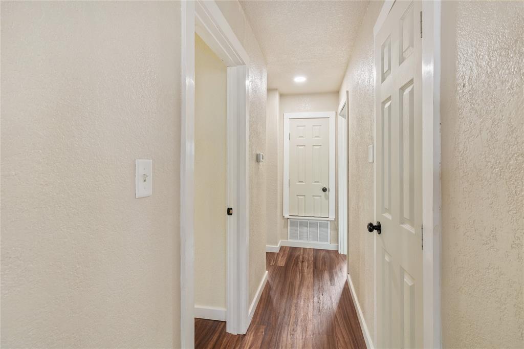 212 East 2nd Street Coleman, TX 76834 - Photo 9 of 17 a view of a hallway with wooden floor and a bathroom