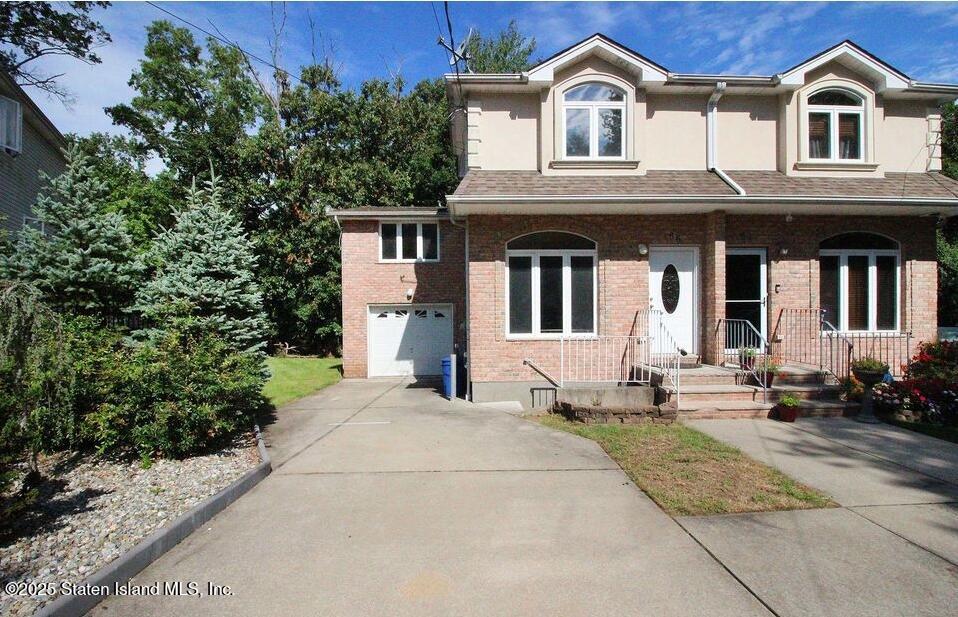 a view of a white house with large windows and a small yard