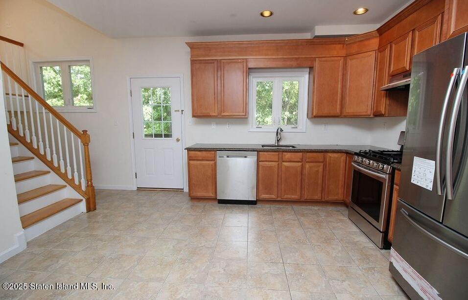 65 Gwenn Loop Staten Island, NY 10314 - Photo 5 of 18 a kitchen with stainless steel appliances a refrigerator sink and cabinets