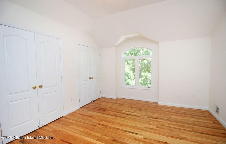 65 Gwenn Loop Staten Island, NY 10314 - Photo 8 of 18 wooden floor in an empty room with a window