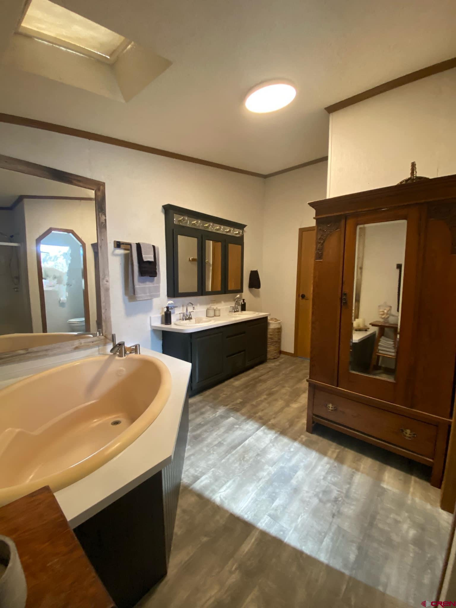 12142 2135th Road Austin, CO 81410 - Photo 13 of 45 a spacious bathroom with a tub and mirror