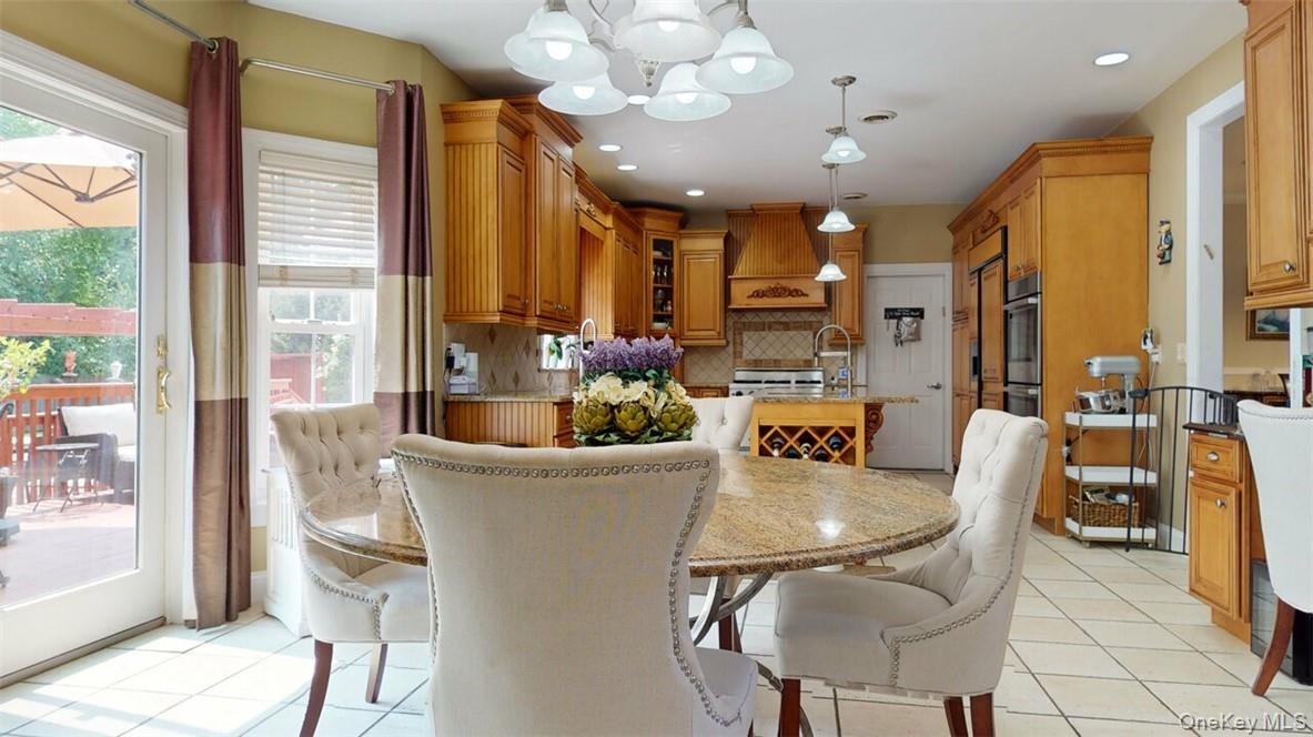 9 Roselawn Road Highland Mills, NY 10930 - Photo 13 of 46 Breakfast area with bay windows, sliders to deck, ceramic tile floors, 8 ft, extra-thick beveled edge granite island with prep sink, big round matching granite Table.