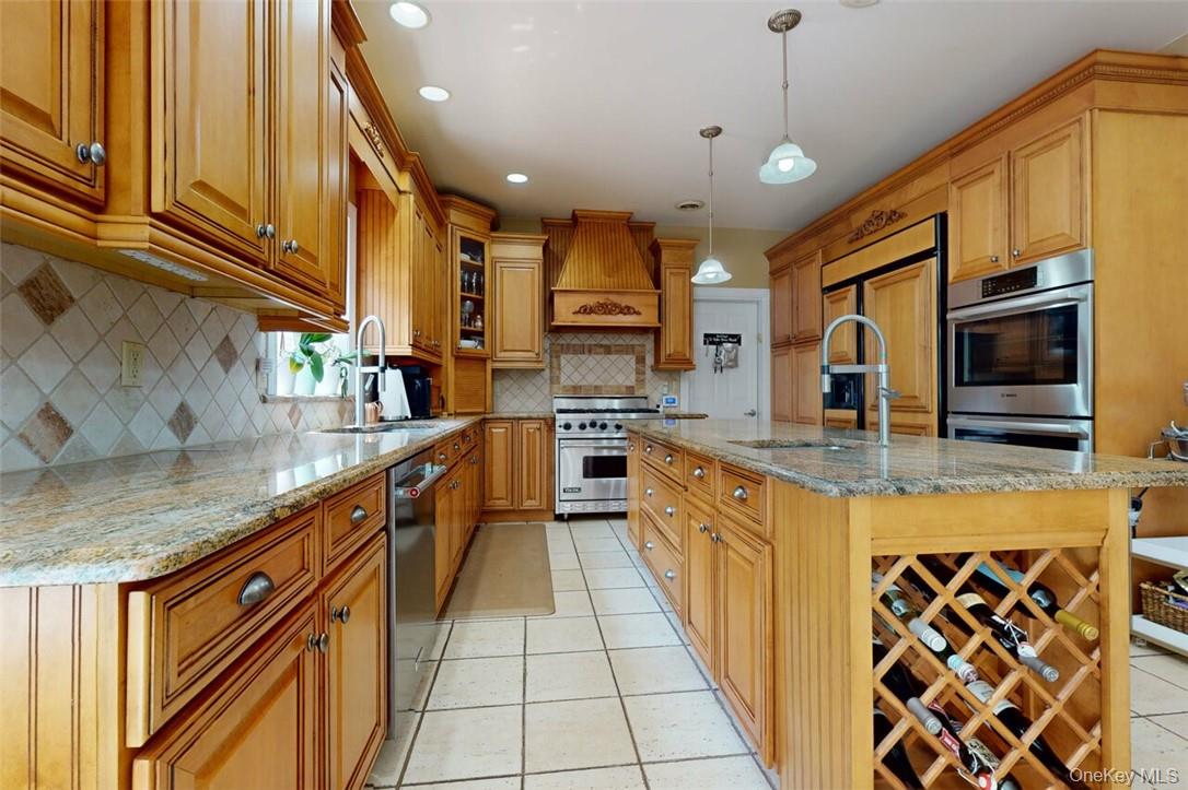 9 Roselawn Road Highland Mills, NY 10930 - Photo 14 of 46 Kitchen with decorative backsplash, high quality appliances, an island with sink, premium range hood, wine tack, and light tile patterned ceramic floors