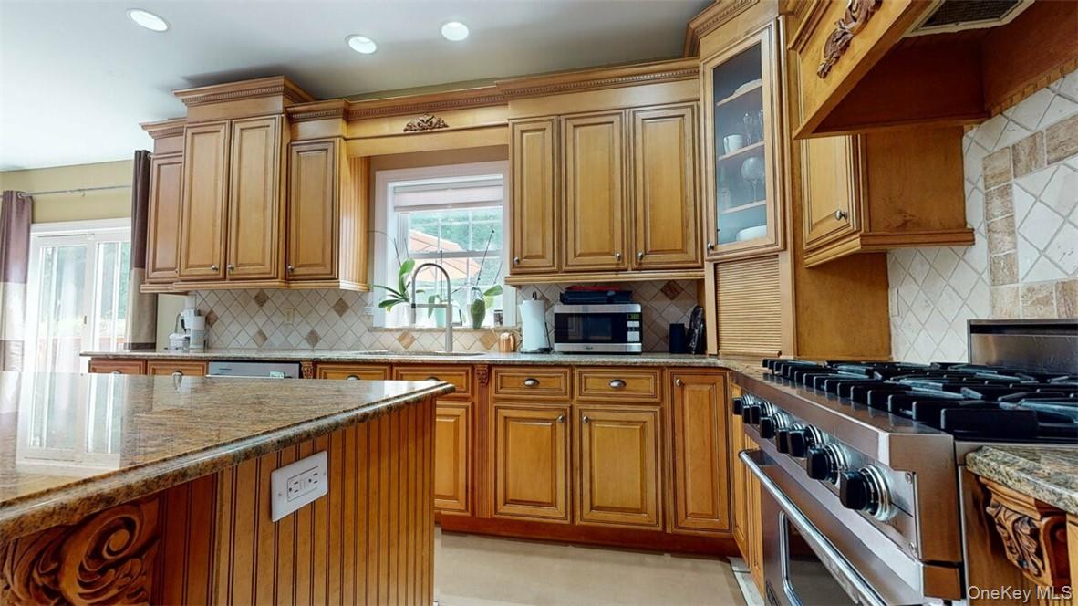 9 Roselawn Road Highland Mills, NY 10930 - Photo 16 of 46 Kitchen with appliances with stainless steel finishes, sink, decorative backsplash, and light stone countertops
