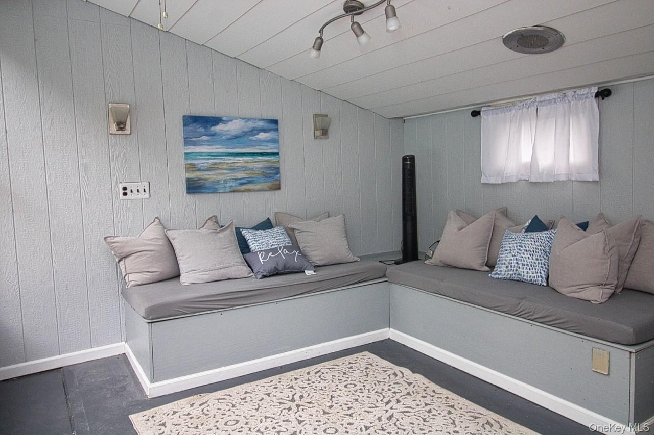 9 Roselawn Road Highland Mills, NY 10930 - Photo 42 of 46 Living area of Pool House, featuring lofted ceiling, with storage benches, overlooking pool