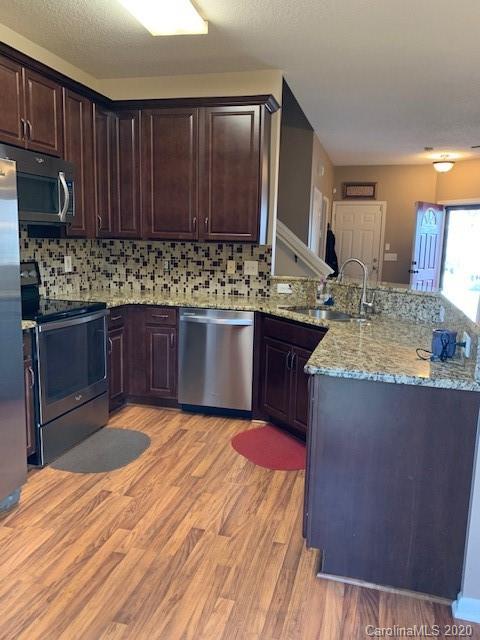 3407 Summerfield Ridge Lane Matthews, NC 28105 - Photo 5 of 11 a kitchen with stainless steel appliances granite countertop a sink stove and granite counter top