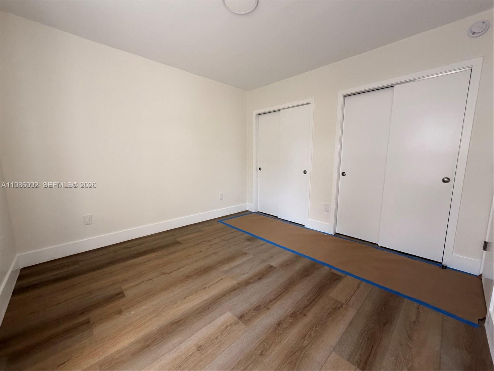 1904 Southwest 17th Avenue, Unit 3 Miami, FL 33145 - Photo 13 of 15 a view of an empty room with wooden floor and a window