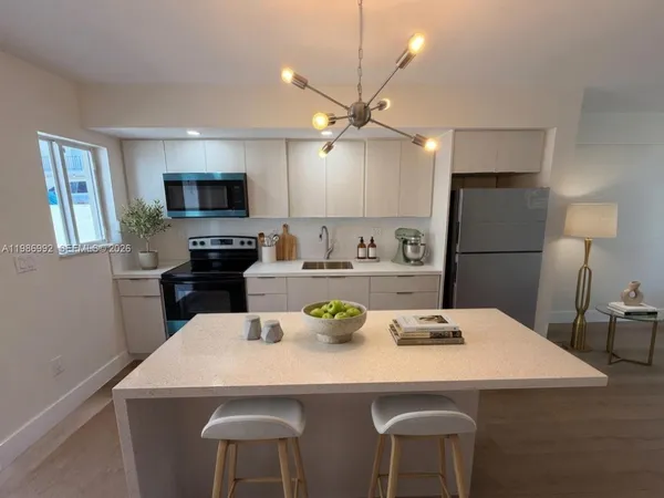 a view of kitchen with microwave stove top oven and cabinets