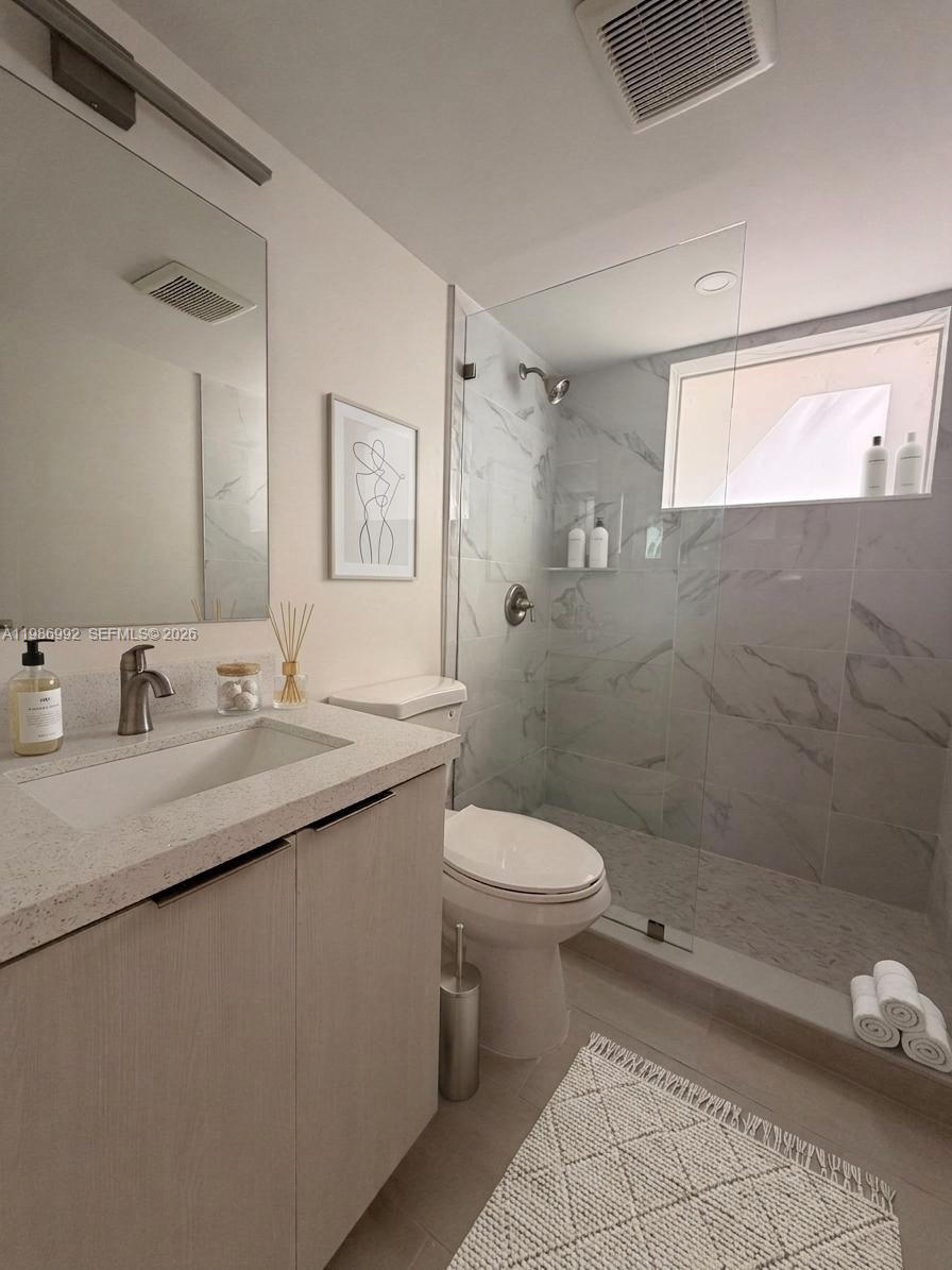 1904 Southwest 17th Avenue, Unit 3 Miami, FL 33145 - Photo 4 of 15 a bathroom with a granite countertop sink a toilet and shower