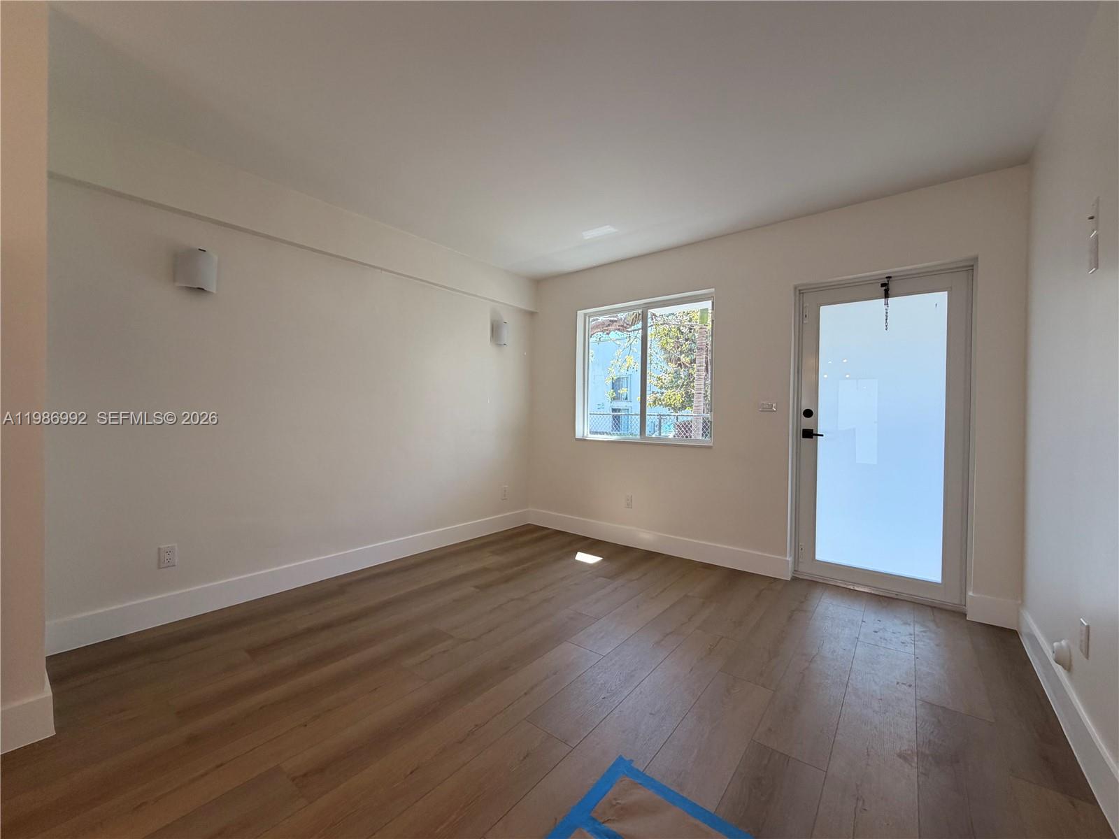 1904 Southwest 17th Avenue, Unit 3 Miami, FL 33145 - Photo 8 of 15 an empty room with wooden floor and windows