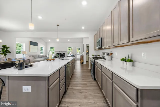 a kitchen with kitchen island granite countertop lots of counter top space a sink wooden cabinets and stainless steel appliances