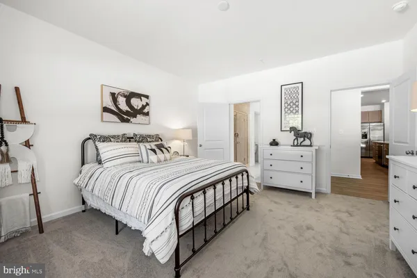 a bedroom with bed and paintings on the wall