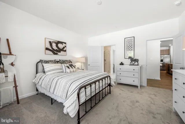 a bedroom with bed and paintings on the wall