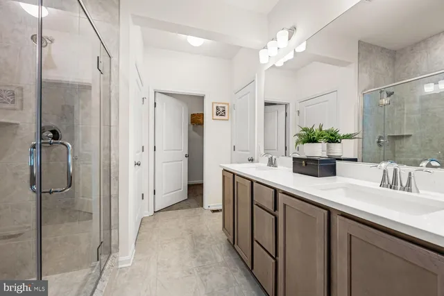 a bathroom with a double vanity sink mirror and shower