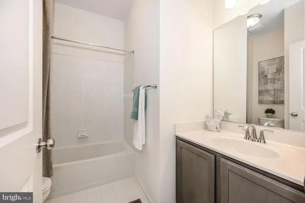 a bathroom with a bath tub sink mirror and shower