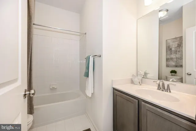 a bathroom with a bath tub sink mirror and shower