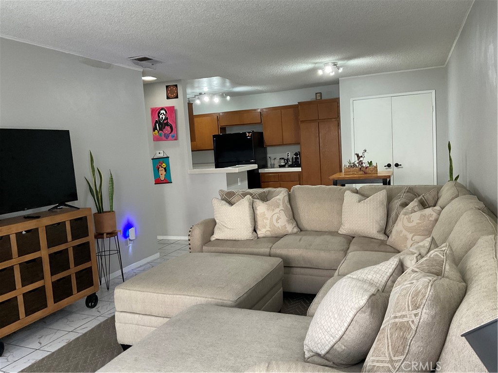 12620 Briarglen Loop, Unit I Stanton, CA 90680 - Photo 16 of 41 a living room with furniture kitchen and a flat screen tv
