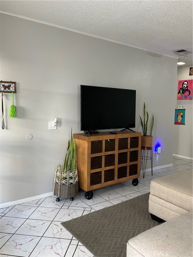 12620 Briarglen Loop, Unit I Stanton, CA 90680 - Photo 17 of 41 a room with furniture and a flat screen tv