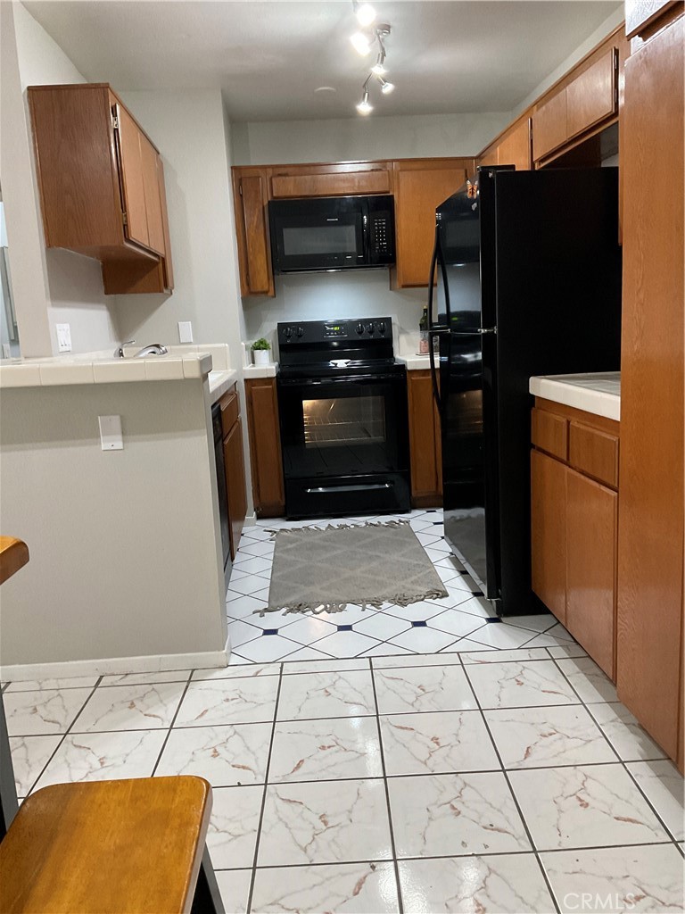 12620 Briarglen Loop, Unit I Stanton, CA 90680 - Photo 20 of 41 a kitchen with stainless steel appliances kitchen island granite countertop a refrigerator and a stove top oven