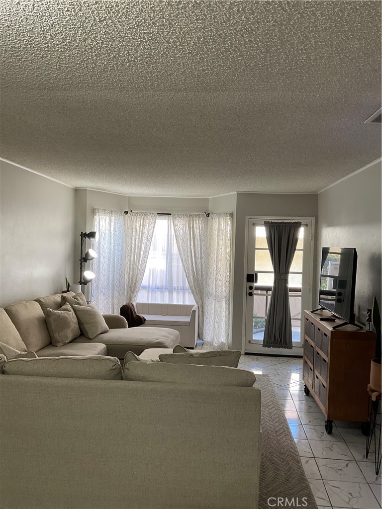 12620 Briarglen Loop, Unit I Stanton, CA 90680 - Photo 2 of 41 a living room with furniture and a flat screen tv