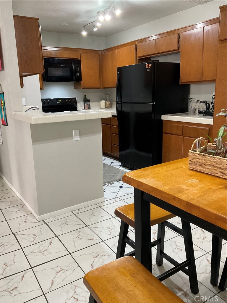 12620 Briarglen Loop, Unit I Stanton, CA 90680 - Photo 21 of 41 a kitchen with stainless steel appliances kitchen island granite countertop a refrigerator and a stove top oven