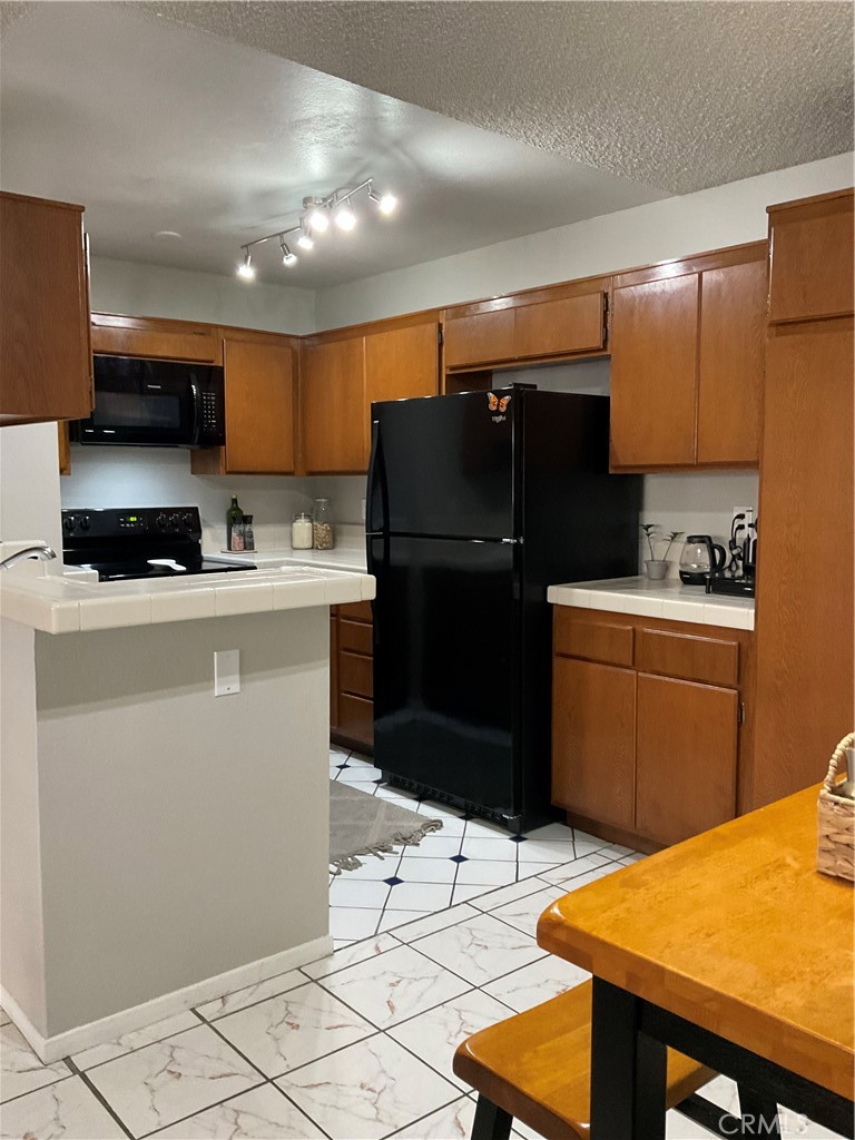 12620 Briarglen Loop, Unit I Stanton, CA 90680 - Photo 22 of 41 a kitchen with stainless steel appliances kitchen island granite countertop a refrigerator a sink a stove a microwave and cabinets