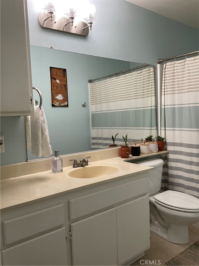 12620 Briarglen Loop, Unit I Stanton, CA 90680 - Photo 29 of 41 a bathroom with a toilet a sink and mirror