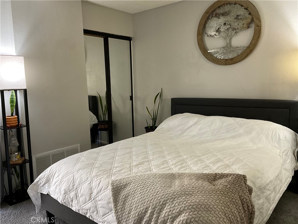 12620 Briarglen Loop, Unit I Stanton, CA 90680 - Photo 32 of 41 a bedroom with a bed and a mirror
