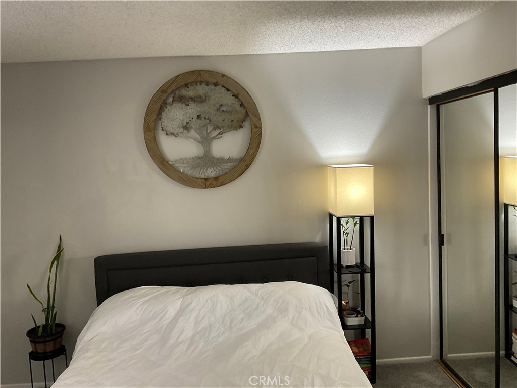 12620 Briarglen Loop, Unit I Stanton, CA 90680 - Photo 34 of 41 a bedroom with a bed and a mirror