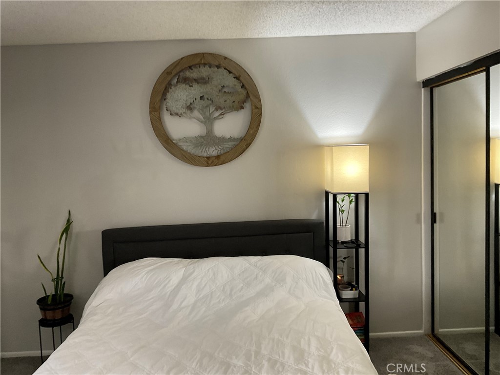12620 Briarglen Loop, Unit I Stanton, CA 90680 - Photo 35 of 41 a bedroom with a bed and a mirror