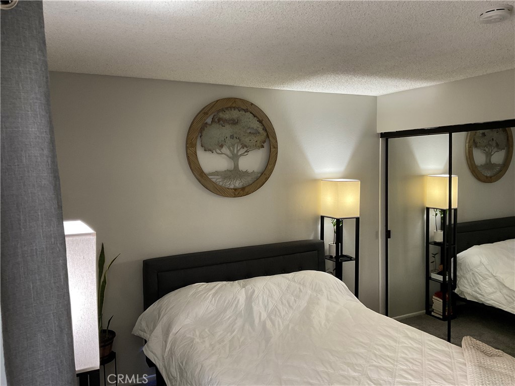 12620 Briarglen Loop, Unit I Stanton, CA 90680 - Photo 36 of 41 a bedroom with a bed and a large mirror