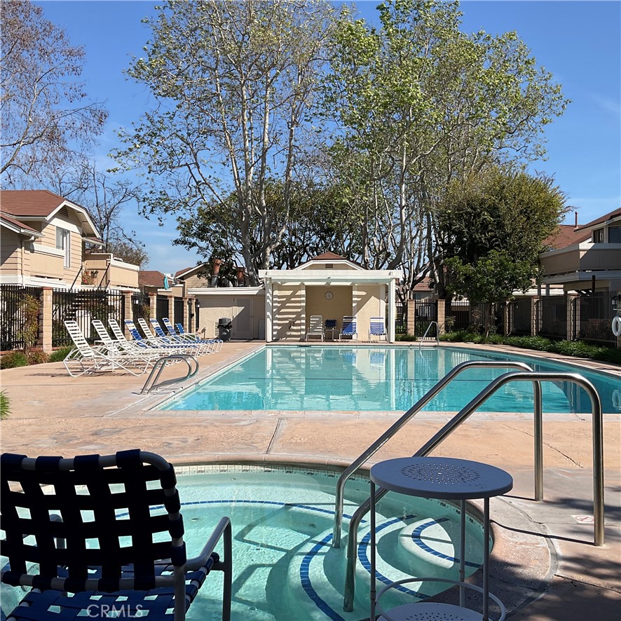 12620 Briarglen Loop, Unit I Stanton, CA 90680 - Photo 38 of 41 a patio with a table and chairs under an umbrella