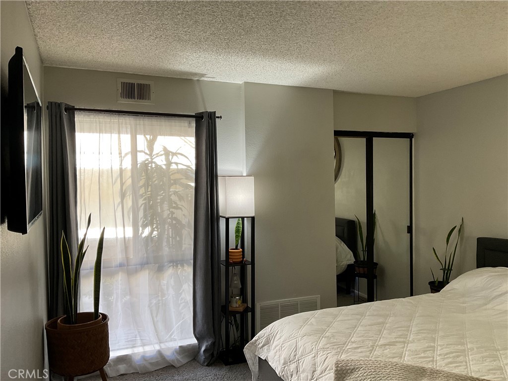 12620 Briarglen Loop, Unit I Stanton, CA 90680 - Photo 4 of 41 a bedroom with a bed and a large mirror