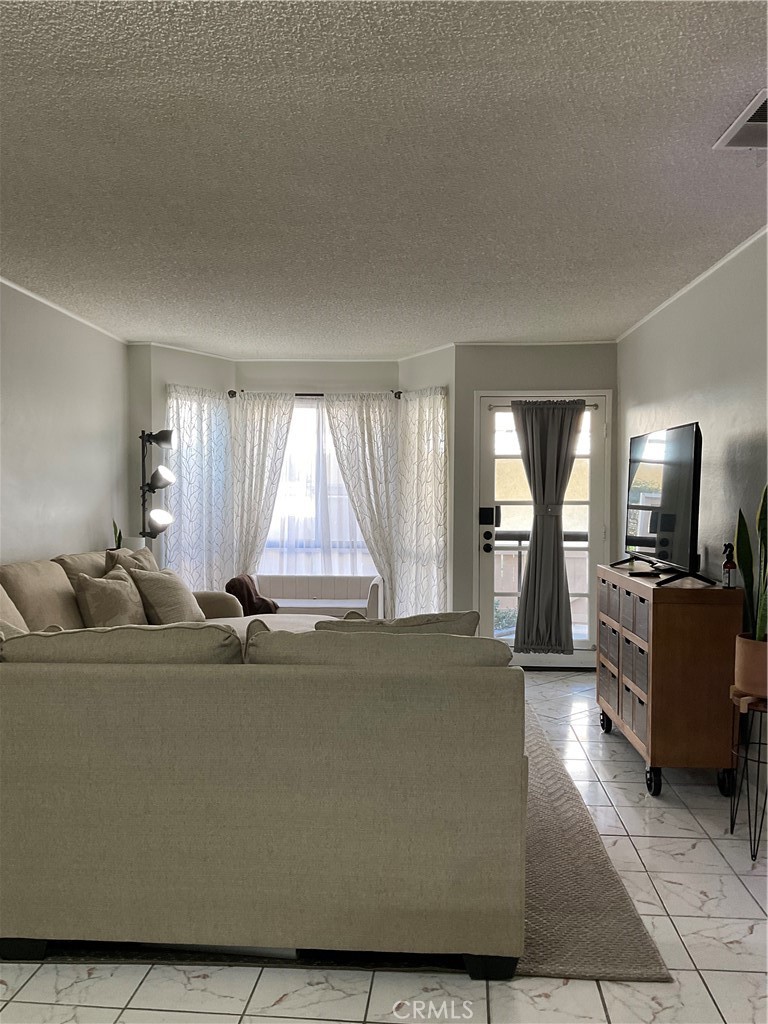 12620 Briarglen Loop, Unit I Stanton, CA 90680 - Photo 9 of 41 a living room with furniture and a flat screen tv