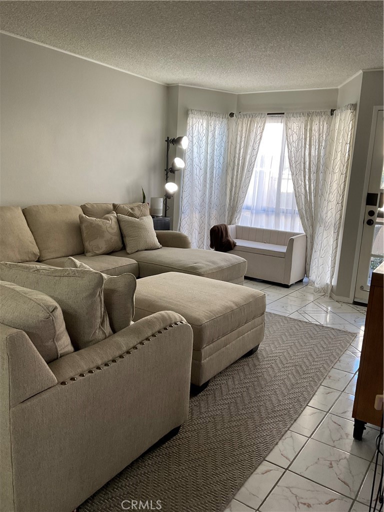 12620 Briarglen Loop, Unit I Stanton, CA 90680 - Photo 10 of 41 a living room with furniture and a large window