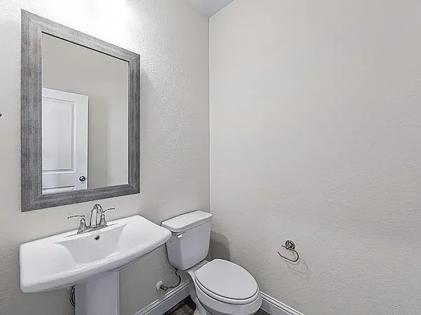 a white toilet sitting next to a bathroom sink