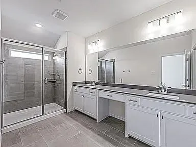 a spacious bathroom with a shower sink and mirror