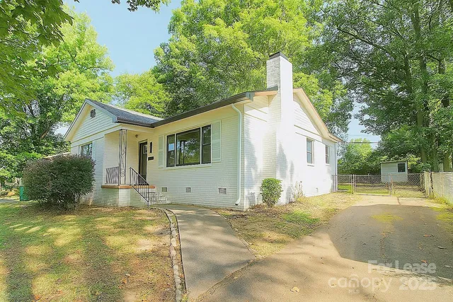 a view of a house with a backyard and trees